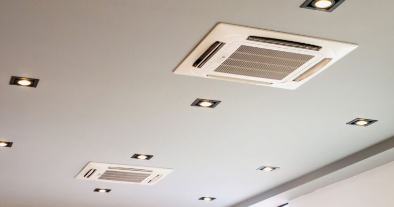 A row of air ducts on a gray ceiling.