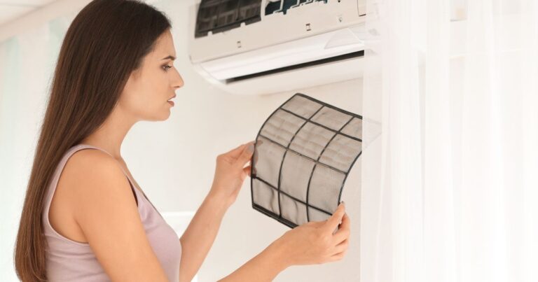 A woman looking at a used and dirty filter from her split type airconditioner.