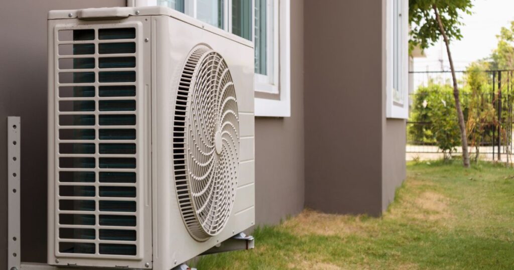 Focus shot of a heat pump installed outdoors, shot during daytime. 