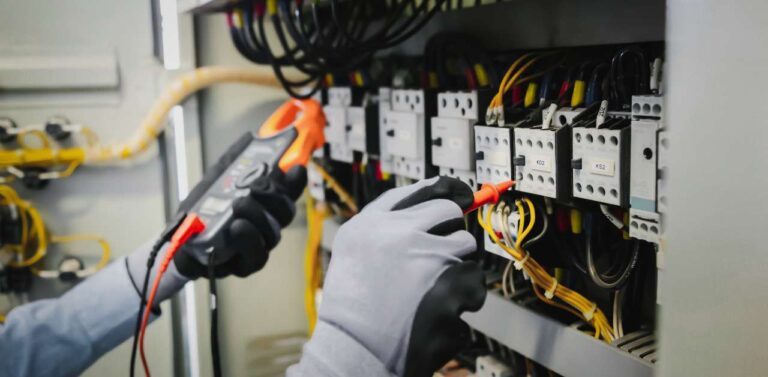 A person performing maintenance works on an electrical wiring system.