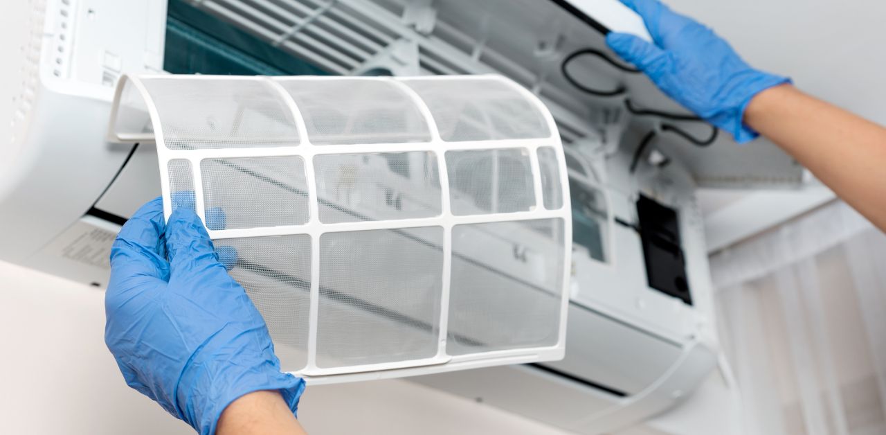 A person changing the AC filter.