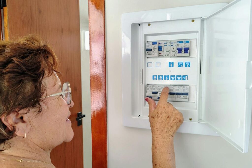 A woman flipping switches in a breaker.