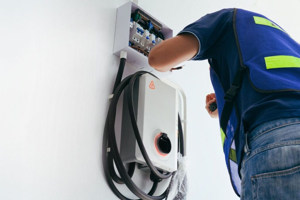 A person inspecting the circuits above a water heater.