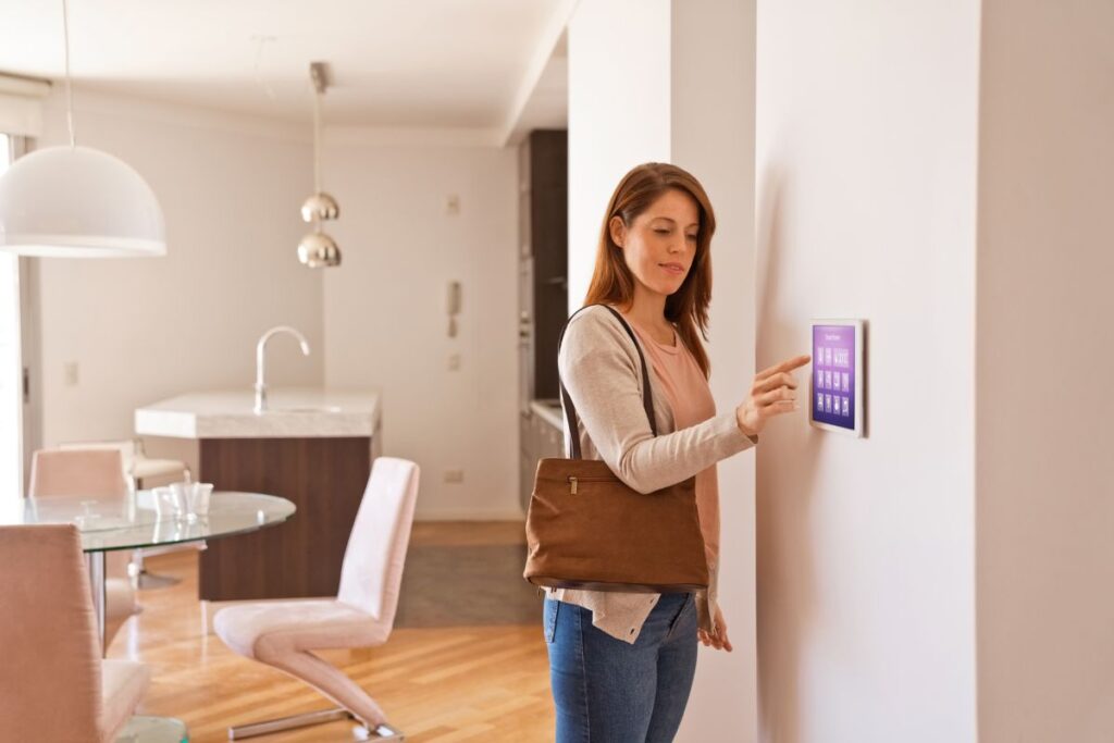 A woman pressing the touchscreen for its thermostat settings.