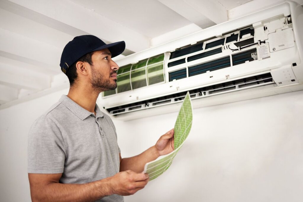 A man replacing a split type unit during an annual AC Maintenance routine.