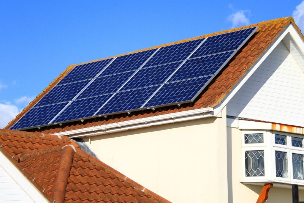 A terra cotta coloured roof with 12 solar power panels.