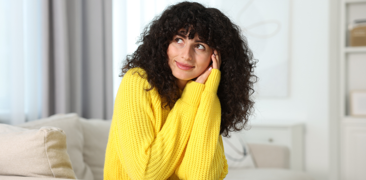A woman in a yellow jumper. This article talks about Gas Ducted Heating vs Ducted Reverse Cycle: Which Is Cheaper to Run in Victoria?